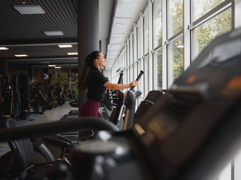 Woman looking out window while on elliptical machine