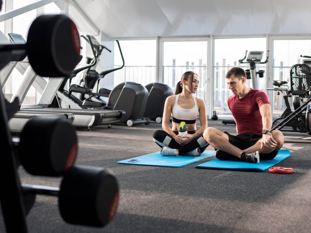 Two exercisers stretching after workout