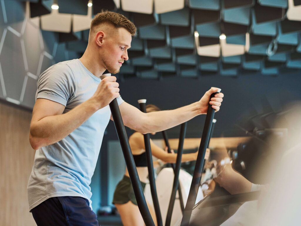 Single man working out on elliptical machine