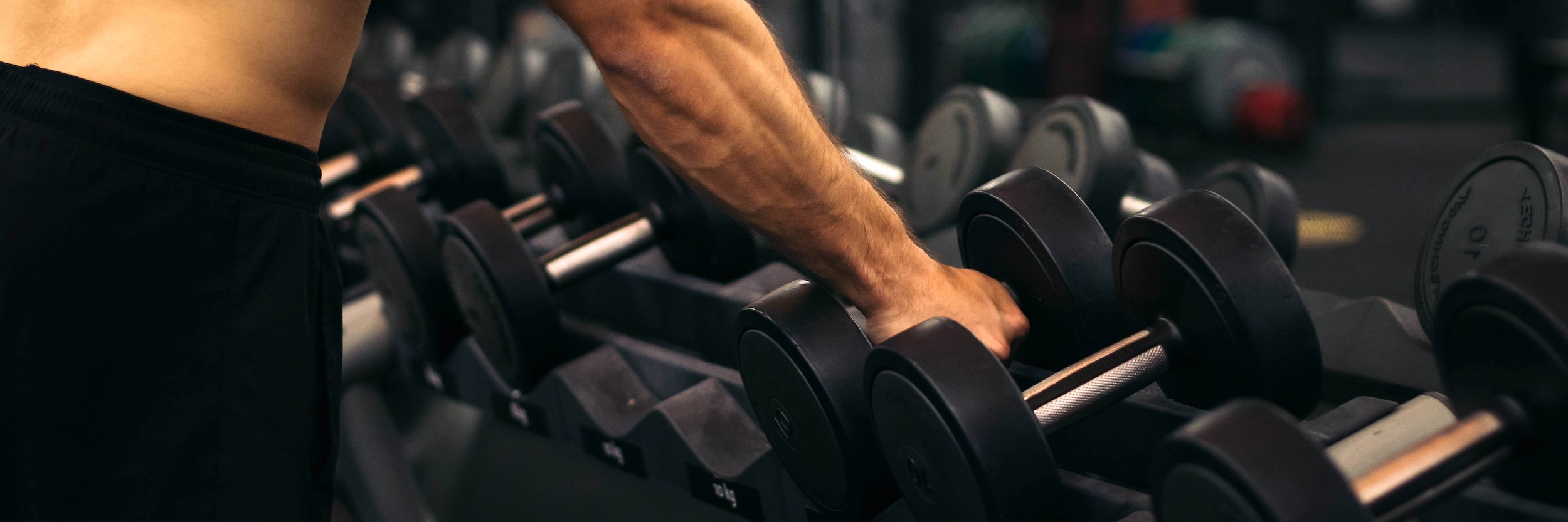 Man grabbing dumbbells from a rack