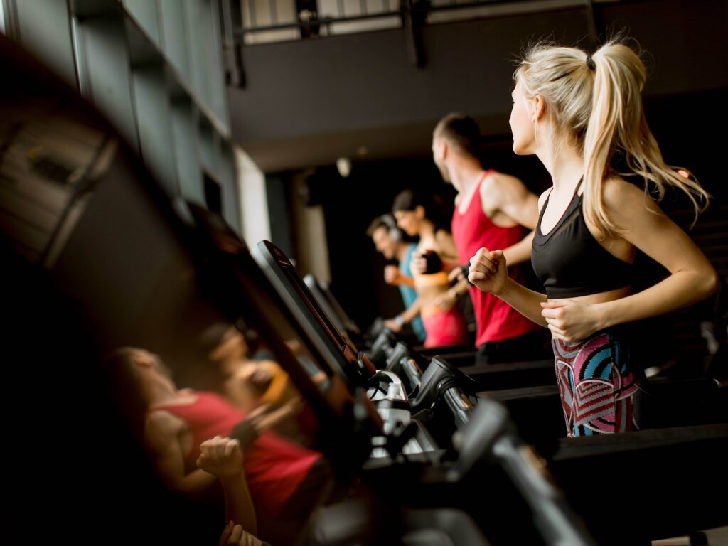Group of athletes running on treadmills in a line