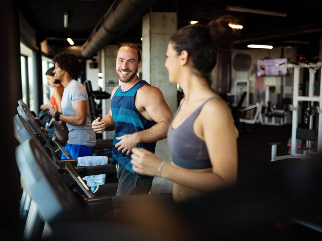Friends laughing while running on treadmill