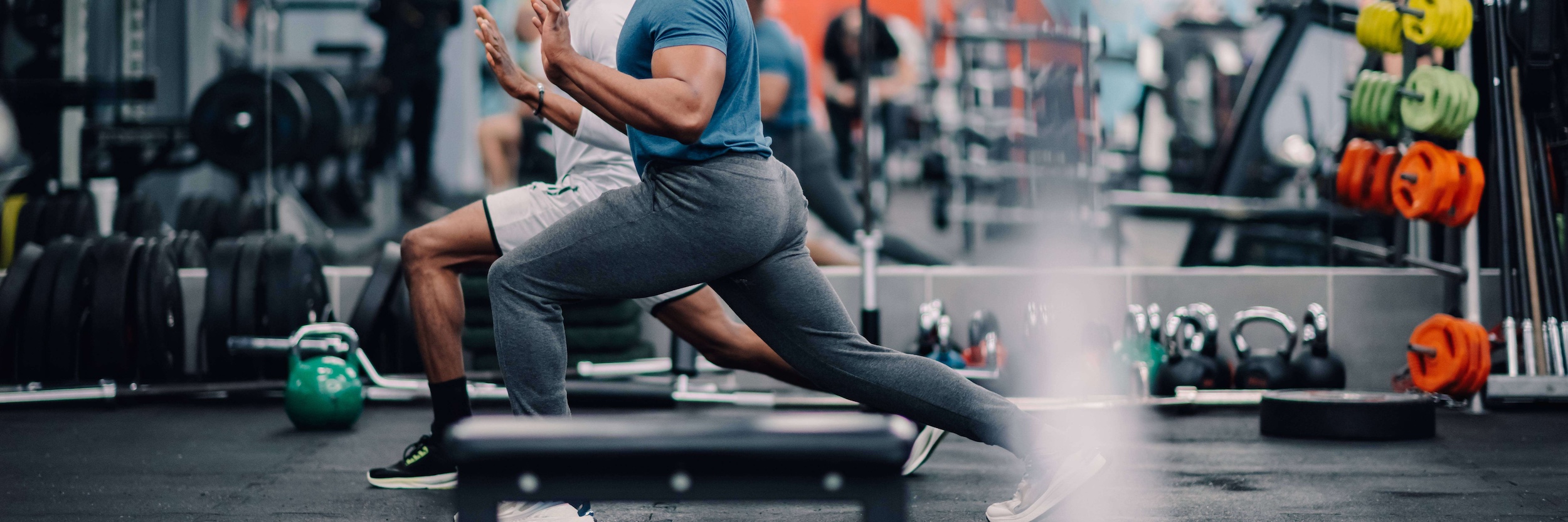 Two men stretching in a gym